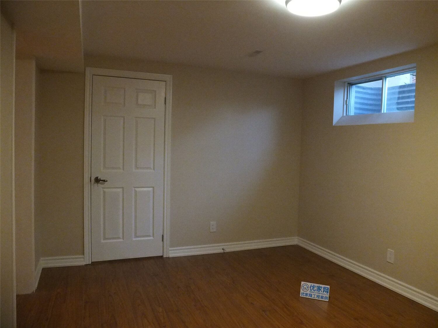 This Markham basement renovation project features newly finished walls, fresh interior painting, and durable laminate flooring installation. The clean wall finish, neutral paint tones, and wood-style flooring create a bright, comfortable living space suitable for a family recreation room or additional living area. Careful detailing around the baseboards and wall edges ensures a smooth and polished appearance throughout the basement interior.