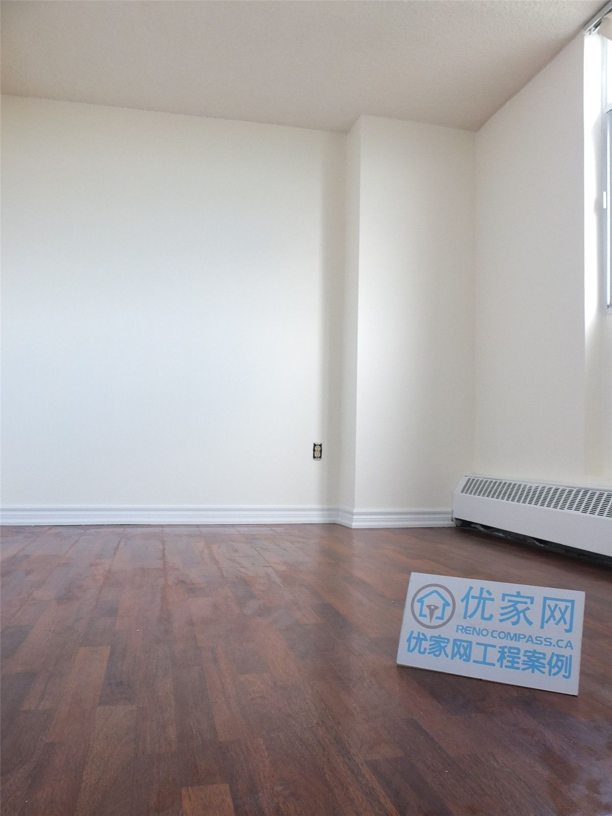 A bright and refreshed condo interior in Scarborough featuring newly installed flooring and clean white walls. This open living space benefits from large windows that enhance natural light, creating a warm and comfortable atmosphere. The renovation improves overall functionality and visual appeal, showcasing professional interior renovation work by a Toronto renovation company.