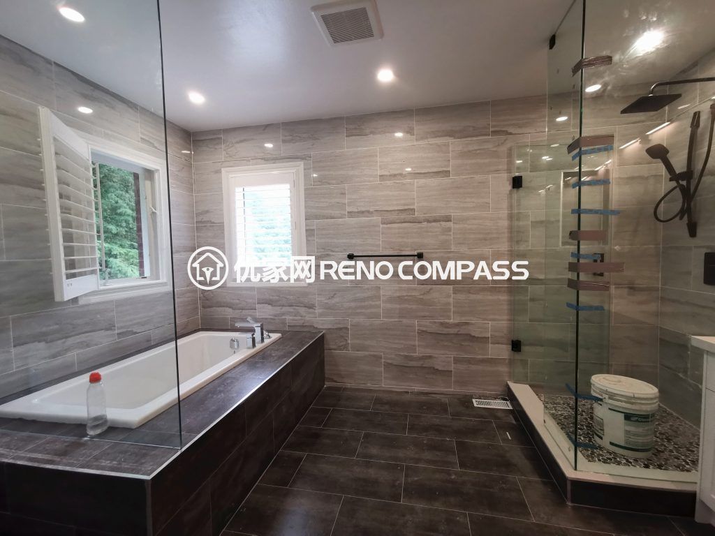 Luxury bathroom interior renovation in Richmond Hill featuring a frameless glass walk-in shower, built-in soaking tub, large-format wall tiles, and modern fixtures. The upgraded layout improves functionality, lighting, and comfort, showcasing high-quality craftsmanship by a professional Toronto renovation company.