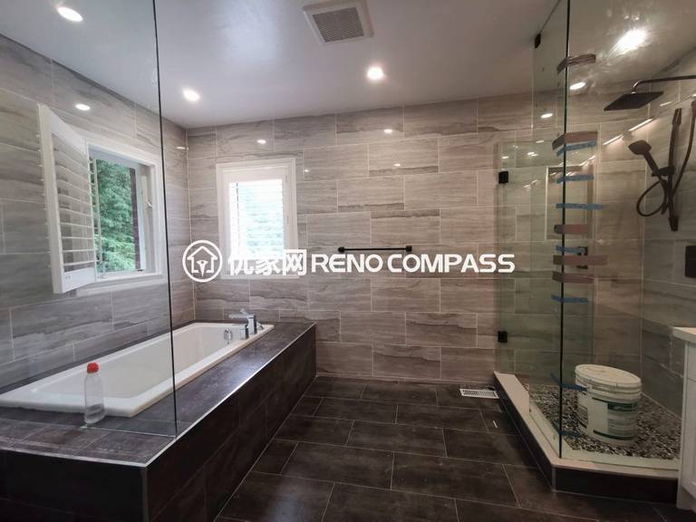 Luxury bathroom interior renovation in Richmond Hill featuring a frameless glass walk-in shower, built-in soaking tub, large-format wall tiles, and modern fixtures. The upgraded layout improves functionality, lighting, and comfort, showcasing high-quality craftsmanship by a professional Toronto renovation company.