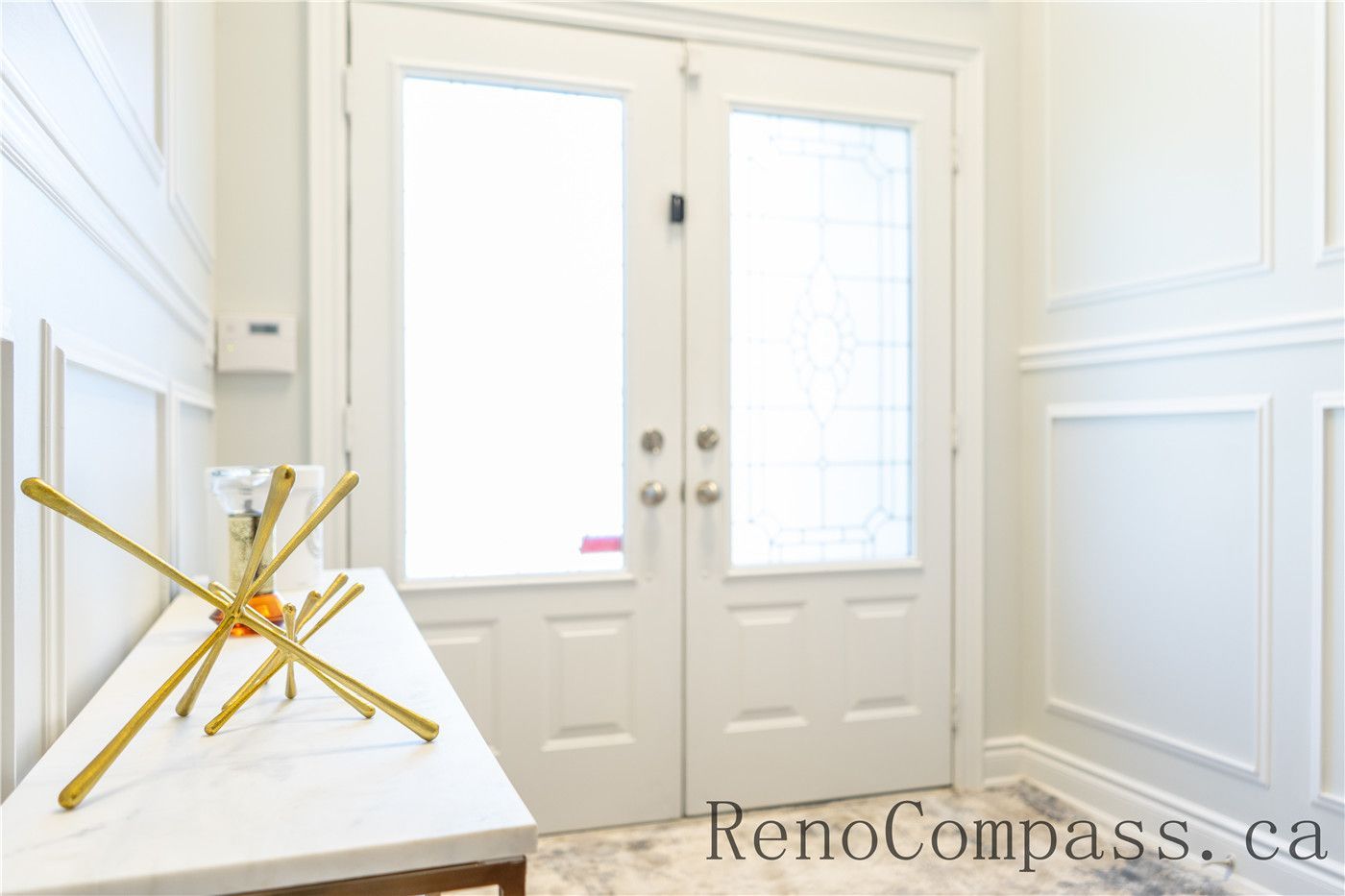 This Richmond Hill home foyer renovation features elegant wall panel detailing, upgraded double entry doors, and a clean, bright entryway layout. The refined finishes and functional design create a welcoming first impression while enhancing home value, showcasing the craftsmanship of a trusted Toronto renovation company specializing in full house interior upgrades.
