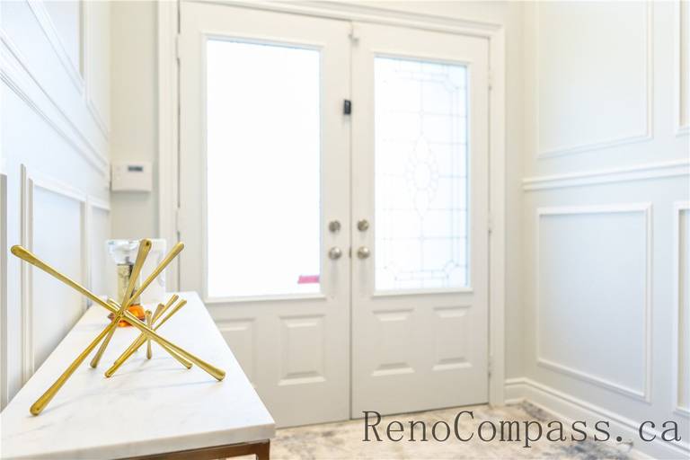 This Richmond Hill home foyer renovation features elegant wall panel detailing, upgraded double entry doors, and a clean, bright entryway layout. The refined finishes and functional design create a welcoming first impression while enhancing home value, showcasing the craftsmanship of a trusted Toronto renovation company specializing in full house interior upgrades.