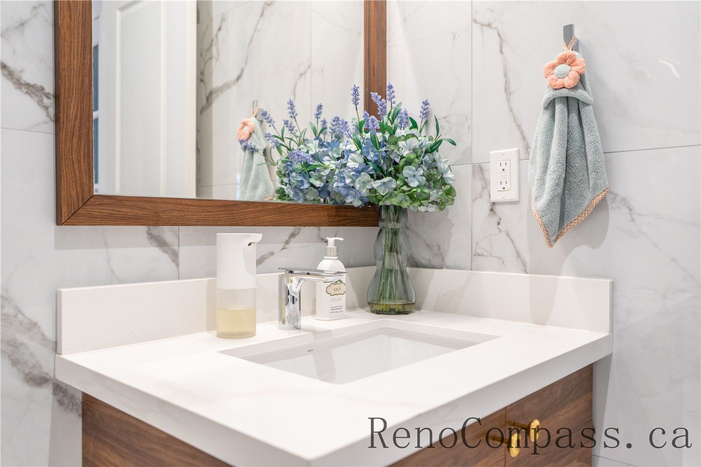 This Richmond Hill bathroom renovation features a modern vanity with quartz countertop, stylish mirror framing, and marble-look wall finishes. The clean layout and upgraded fixtures enhance both functionality and visual appeal, reflecting the quality craftsmanship of a professional Toronto renovation company delivering complete home interior renovation solutions.