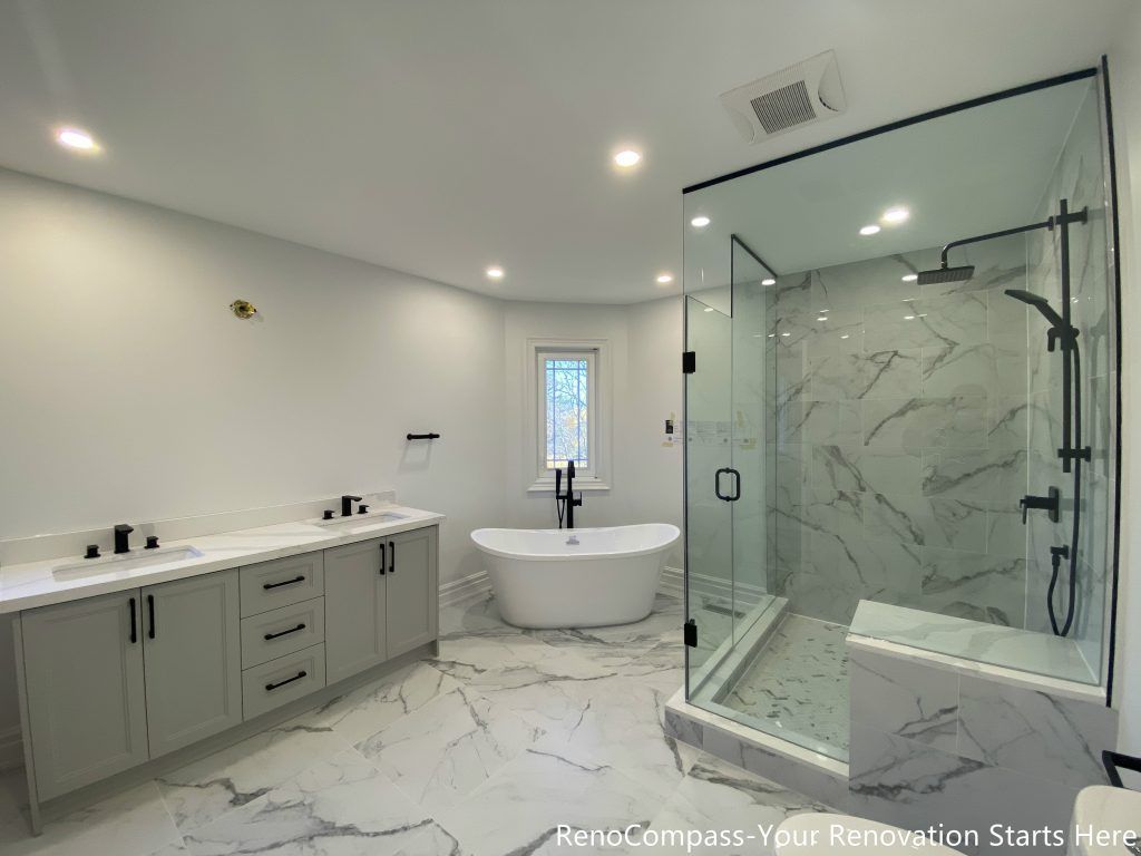 This Thornhill master bathroom renovation presents a bright, open layout featuring a double sink vanity, a freestanding bathtub, and a frameless glass walk-in shower. Marble-look porcelain tiles unify the floor and shower walls, creating a seamless and elegant visual flow throughout the space. Matte black fixtures add modern contrast, while recessed lighting and natural daylight enhance brightness and spatial balance. The thoughtful layout improves functionality, comfort, and long-term usability, delivering a refined and timeless bathroom design.
