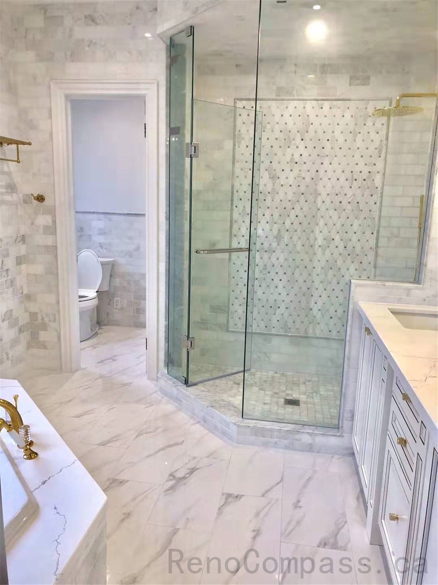 This North York bathroom renovation showcases a walk-in glass shower finished with marble-look floor and wall tiles, a mosaic accent shower wall, and coordinated gold fixtures. The frameless glass enclosure enhances openness while providing a clean, elegant, and easy-to-maintain shower space.