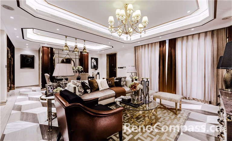 This Toronto interior renovation project showcases a refined luxury living room design featuring a custom tray ceiling with integrated lighting, a statement chandelier, elegant marble flooring, and high-end furniture styling. The space blends classic detailing with modern sophistication, creating a warm yet upscale atmosphere. Designed and built by a professional Toronto Renovation Company, this project highlights craftsmanship, lighting design, and premium interior finishing.