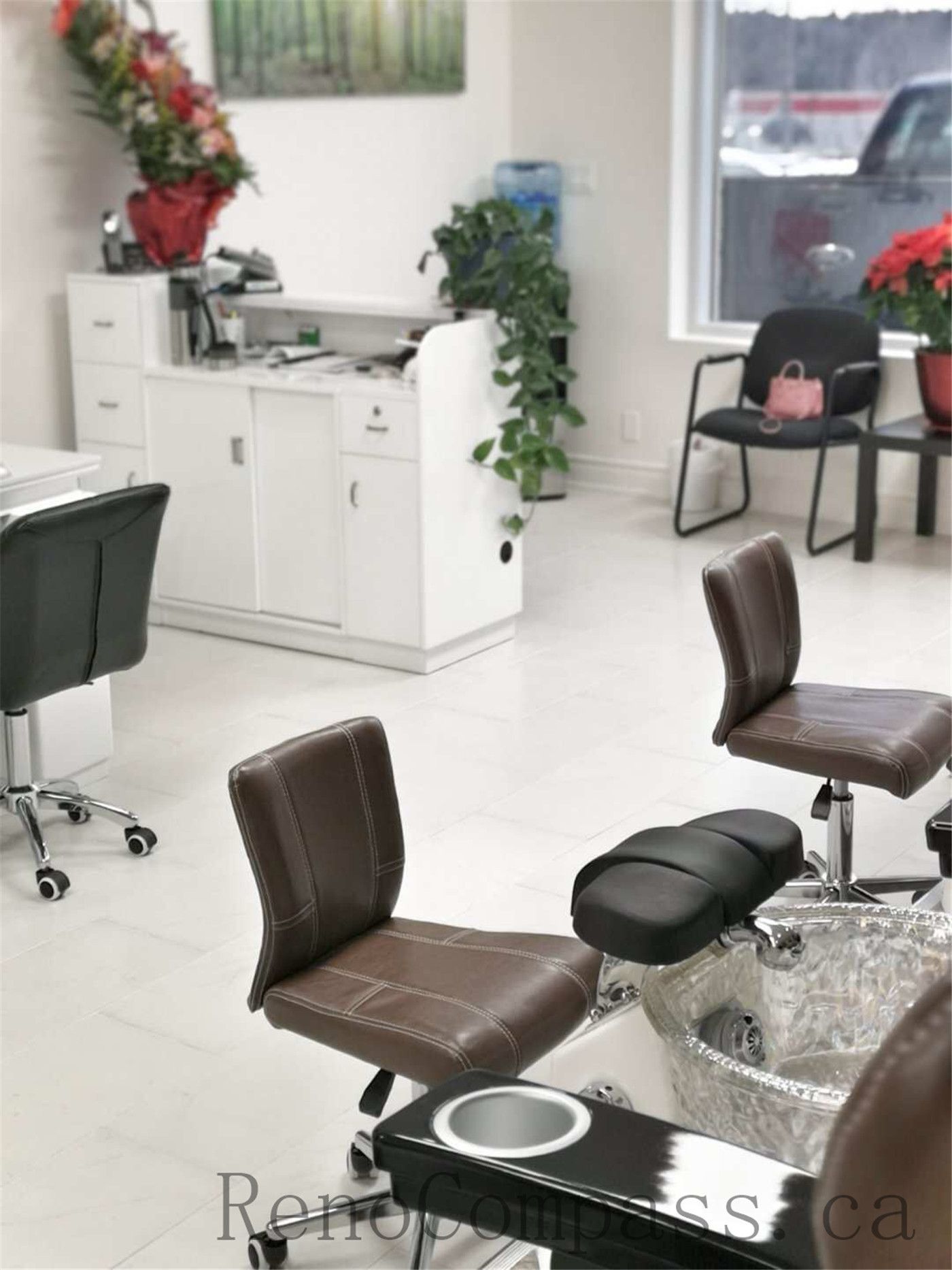 Toronto nail spa commercial renovation featuring a clean and welcoming reception counter, modern cabinetry, and a bright pedicure area with ergonomic client seating and integrated spa basins. The upgraded salon interior emphasizes hygiene, comfort, and efficient layout planning to enhance daily operations. Commercial beauty salon renovation completed by Reno Compass Inc., a professional Toronto renovation company specializing in nail spa and retail spaces.