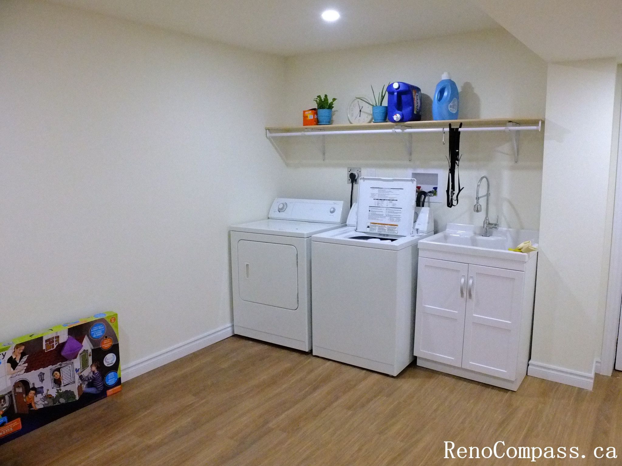 This Richmond Hill basement renovation features a clean and functional laundry room with upgraded washer and dryer, custom shelving, integrated utility sink, and durable flooring. The bright recessed lighting and smart layout maximize space efficiency while maintaining a modern aesthetic. Completed by a trusted Toronto Renovation Company, this basement transformation combines practicality with polished design.