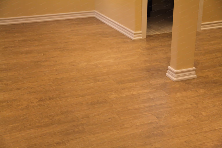 This image focuses on the finished basement flooring and baseboard details in a Markham basement renovation project. The space features durable, low-maintenance flooring suitable for basement environments, paired with clean white baseboards that create a polished transition between walls and floors. Attention to material selection and finishing details ensures long-term performance, visual consistency, and everyday comfort, delivered by a professional Toronto renovation company.
