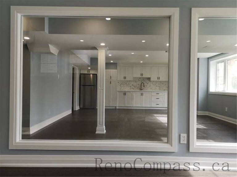 This cozy basement lounge in Aurora features elegant wall finishes, large windows, and modern flooring. The space is designed to bring warmth and openness, beautifully finished by Reno Compass.