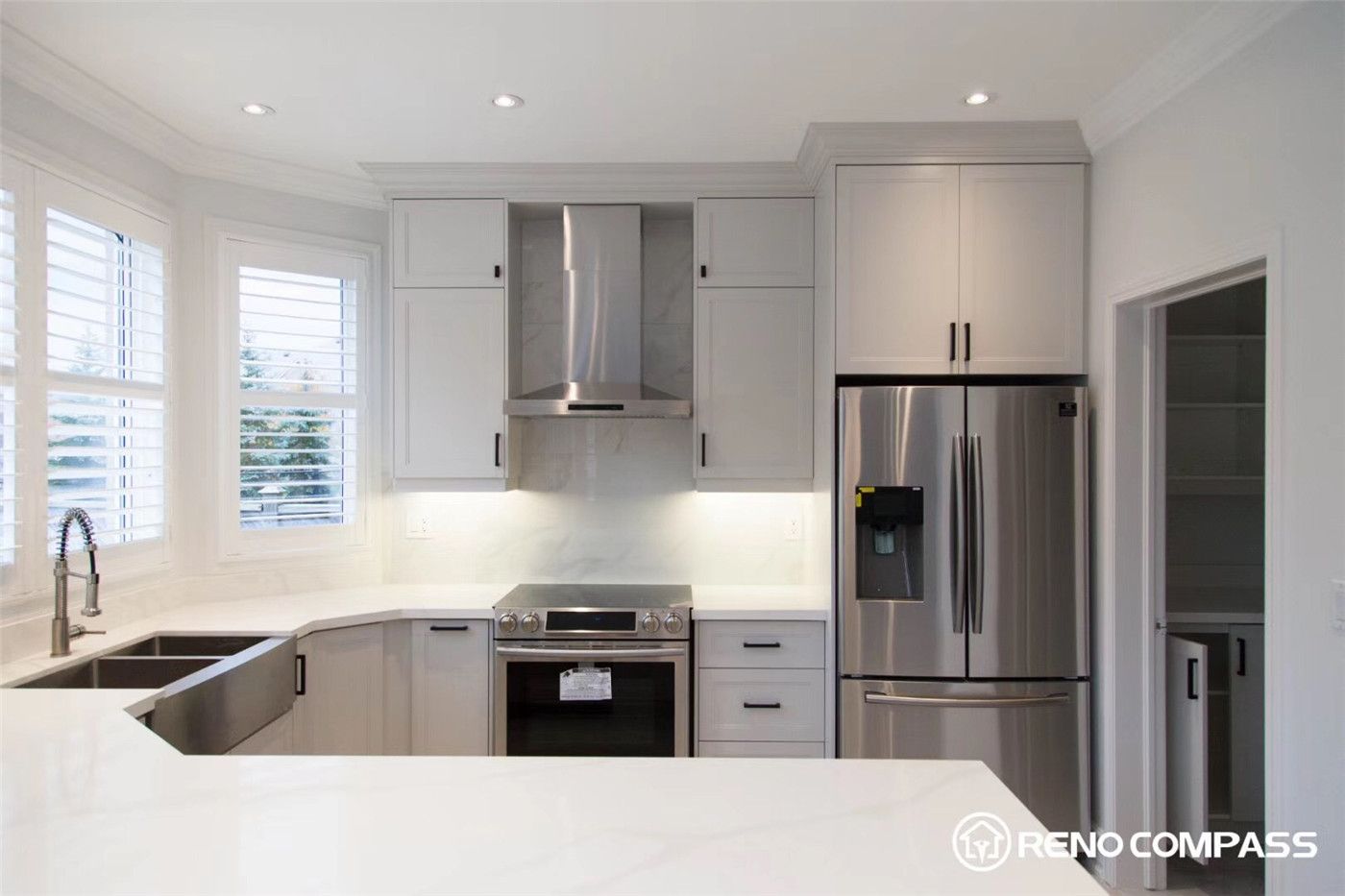 This Markham kitchen renovation highlights custom white shaker cabinets paired with a sleek stainless steel range hood and marble-look backsplash. The clean lines, modern finishes, and built-in cabinetry create a bright, functional, and elegant cooking space designed for both style and everyday use.