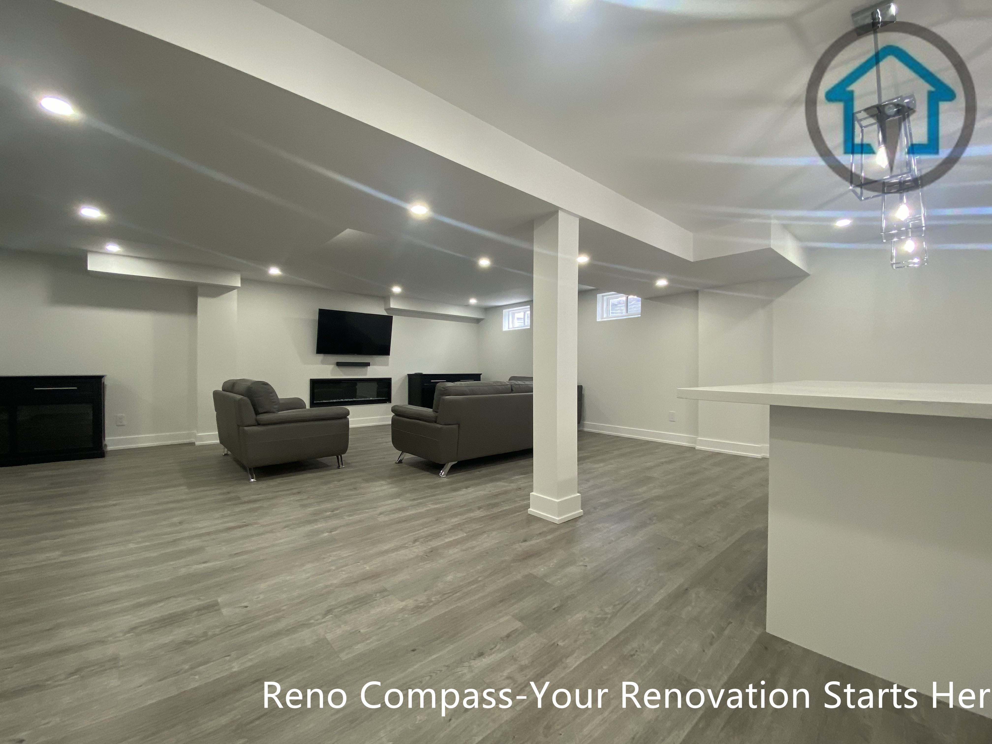 This image showcases a spacious basement family room renovation in Newmarket completed by a professional Toronto renovation company. The open layout features wood-look flooring, recessed ceiling lighting, and structural columns that maintain openness while clearly defining the entertainment area. The basement is designed to accommodate seating, media setup, and flexible use, making it ideal for family living, gatherings, or rental purposes.