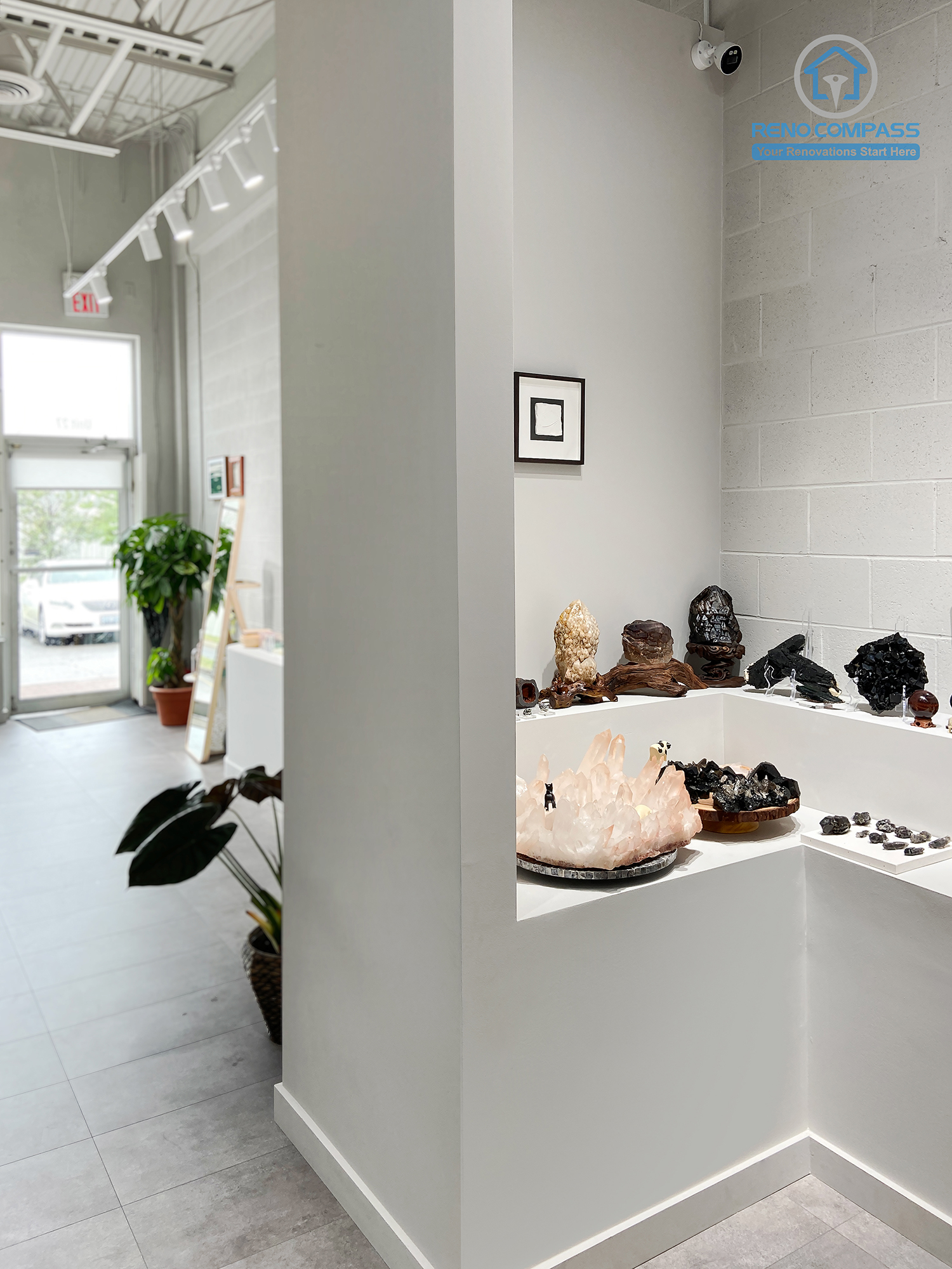 This image highlights a custom-built crystal display corner in a renovated crystal shop located in Markham. The design features clean white display niches, minimalist shelving, and focused lighting to enhance the visual impact of crystals and spiritual items. Neutral wall finishes and polished flooring create a calm, gallery-like retail atmosphere. As a Toronto renovation company, Reno Compass specializes in boutique retail renovations that balance aesthetics, functionality, and customer flow.