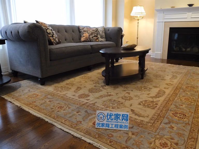 This Aurora flooring renovation showcases newly installed hardwood flooring in a cozy living room space featuring a classic fireplace and elegant seating area. The rich wood flooring enhances the warmth of the room and pairs beautifully with the neutral wall tones and traditional décor. Completed by a trusted Toronto renovation company, the flooring upgrade improves both the visual appeal and long-term durability of this comfortable living area.