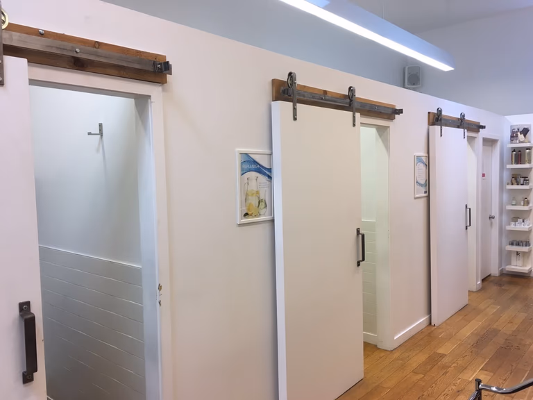 This Toronto spa renovation features a sleek and functional salon setup with modern black washing stations, custom cabinetry, and a clean workspace layout. Designed for both efficiency and aesthetics, the space enhances client comfort while maintaining a professional, high-end appearance.