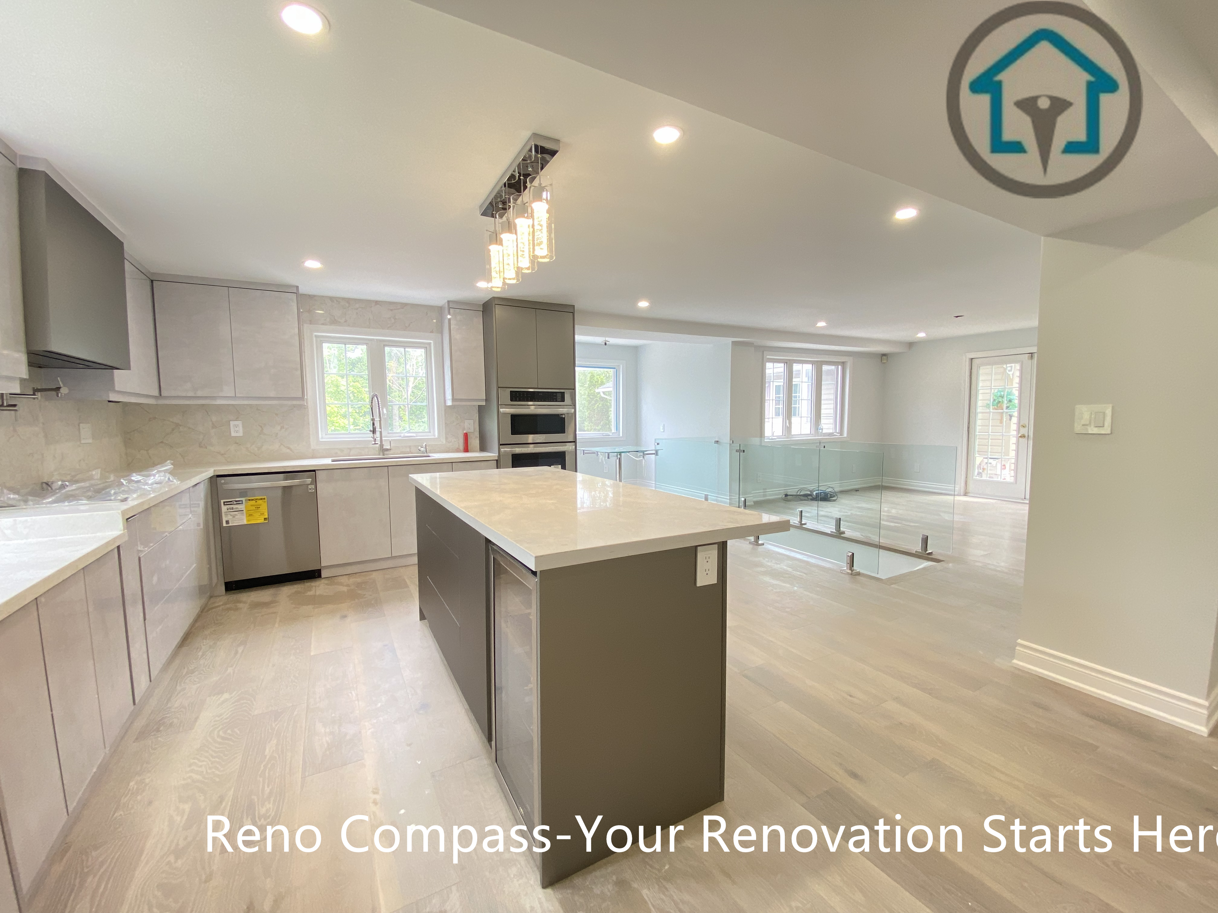 This kitchen island showcases a streamlined design with quartz surfaces, built-in storage, and modern pendant lighting above. The island serves as both a functional workspace and a visual focal point within the open kitchen layout.