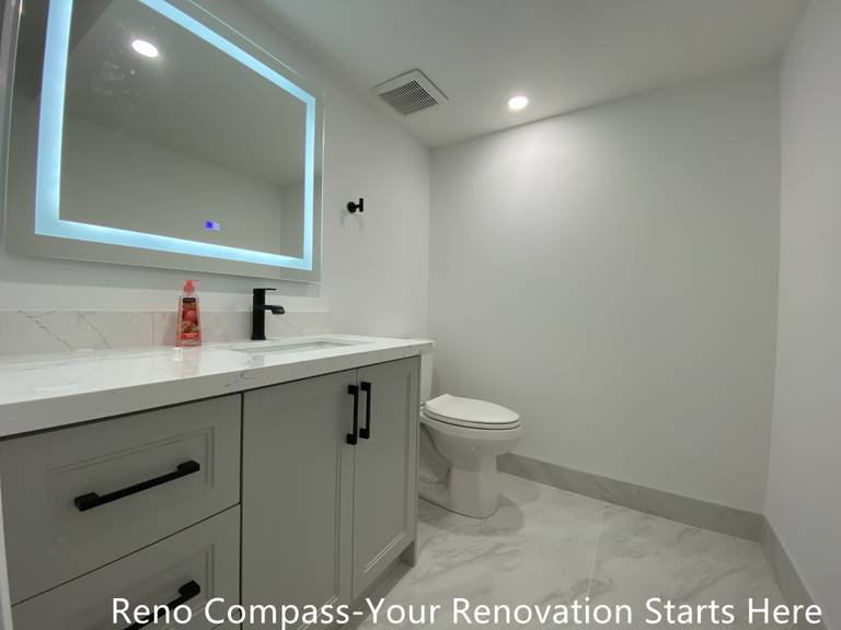 This Bradford basement bathroom renovation features a modern floating vanity, quartz countertop, matte black fixtures, and large-format tile flooring. Designed for durability and easy maintenance, this space enhances everyday functionality while maintaining a clean, contemporary look as part of a full basement renovation by a Toronto renovation company.