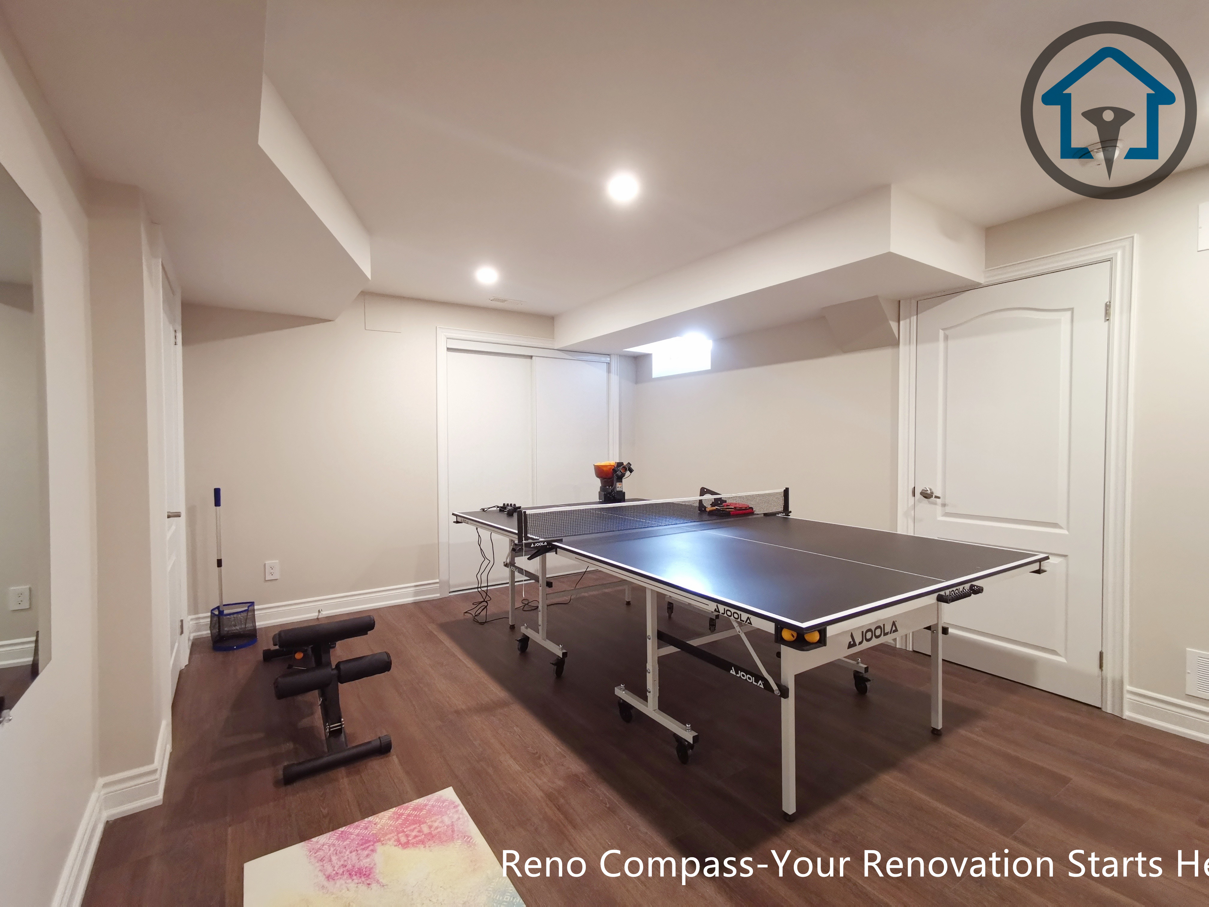 Basement media zone renovation in Markham with projector setup, ambient ceiling lighting, and wood feature elements enhancing comfort and visual focus.