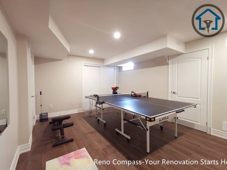 Basement media zone renovation in Markham with projector setup, ambient ceiling lighting, and wood feature elements enhancing comfort and visual focus.