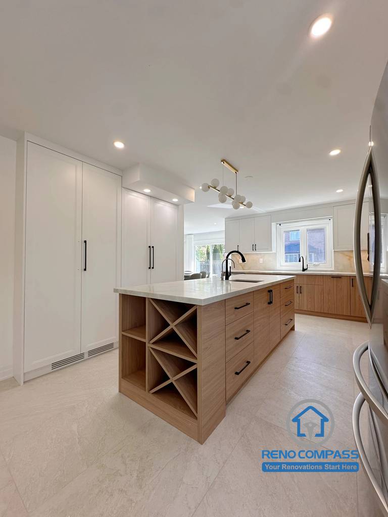 A custom kitchen featuring a multifunctional island with a built-in wine rack, floor-to-ceiling pantry cabinetry, quartz countertops, and premium storage solutions. Completed as part of a luxury whole home renovation in Markham, Ontario, this modern kitchen combines elegant design, practical organization, and expert craftsmanship by Reno Compass.