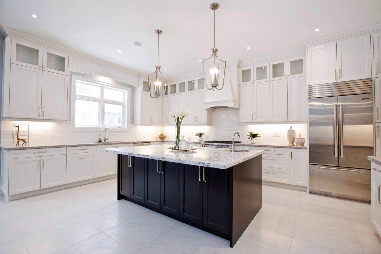 Modern luxury kitchen completed as part of a Toronto design build custom build project, featuring a large central island, custom white cabinetry, quartz countertops, and premium stainless steel appliances. This whole house renovation Toronto project highlights the clean design, spacious layout, and high-end finishes that define luxury custom kitchens in Toronto homes.