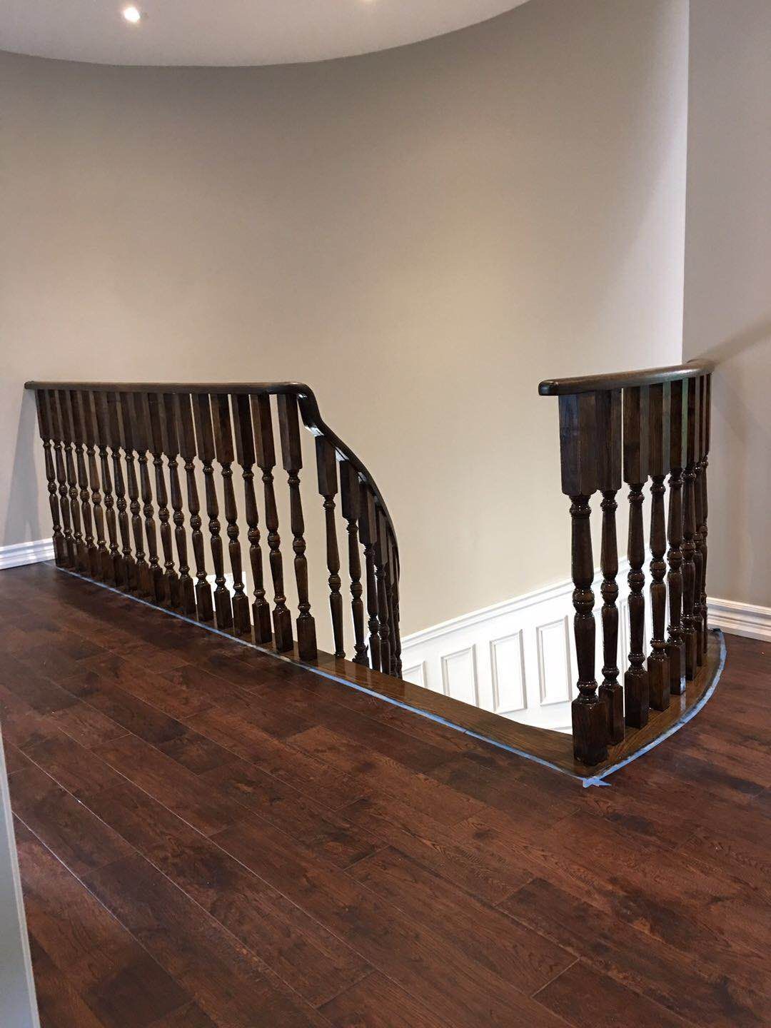 This Toronto interior renovation highlights a beautifully crafted curved hardwood staircase featuring solid wood railings, detailed balusters, and elegant wall panel molding. The staircase upgrade enhances the architectural character of the home while providing durability, craftsmanship, and a warm, timeless appearance.