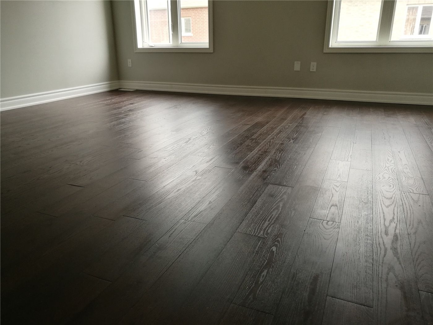 This image highlights hardwood flooring after a Markham interior renovation, featuring dark wood planks, clean baseboard detailing, and a smooth finish that enhances durability and overall interior quality.