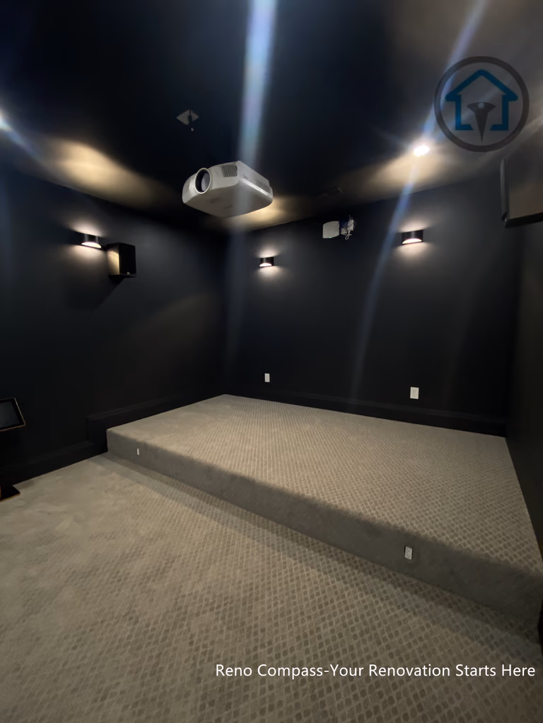 This image features a custom basement home theater renovation in Richmond Hill, designed with dark wall finishes, wall-mounted ambient lighting, and a raised platform for optimal viewing experience. The enclosed layout enhances sound control and visual focus, creating a private cinematic environment within the home. Completed by Reno Compass, this home theater renovation demonstrates thoughtful space planning and lighting design tailored for immersive entertainment in a modern basement setting.