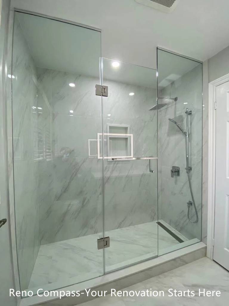 This Oakville interior renovation features a modern walk-in shower designed with frameless glass panels and full-height marble-look porcelain tiles. The clean glass enclosure enhances visual openness while allowing natural and artificial light to flow through the space. A rain shower system, wall-mounted hand shower, and built-in niche provide both comfort and functionality. The minimalist layout and neutral stone tones create a calm, spa-inspired bathroom environment that is durable, easy to maintain, and ideal for long-term residential use. This project reflects the precision detailing and modern design standards expected from a professional Toronto renovation company.