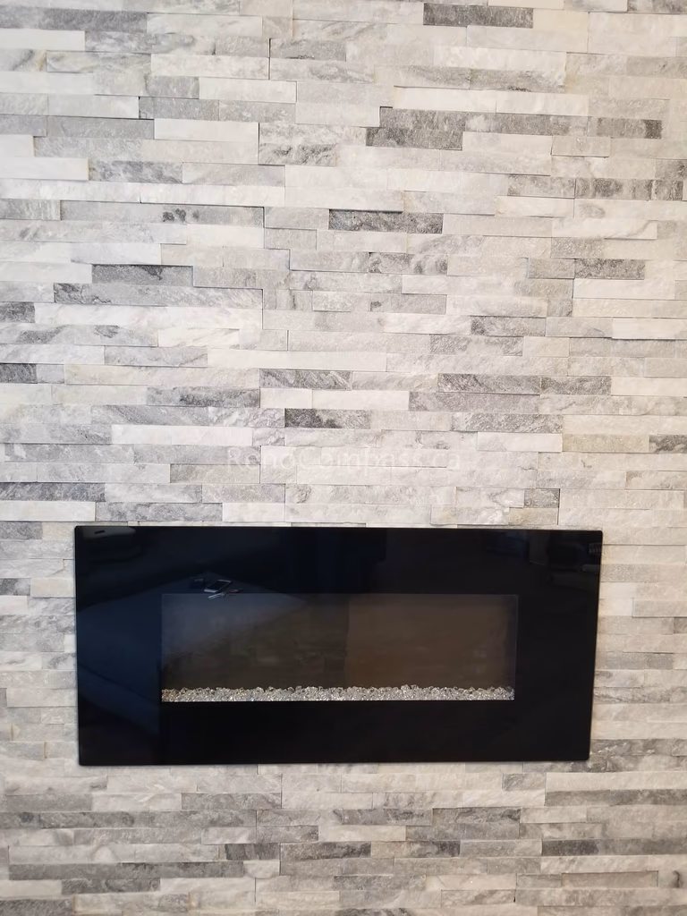 This Mississauga interior renovation features a contemporary stone feature wall paired with a sleek linear electric fireplace, creating a warm and elegant focal point for the living space. The stacked stone texture adds depth and luxury, while the built-in fireplace enhances both comfort and visual appeal.

Completed by Reno Compass Inc., this modern interior upgrade blends functionality, style, and high-quality craftsmanship to elevate the home’s overall atmosphere and property value.