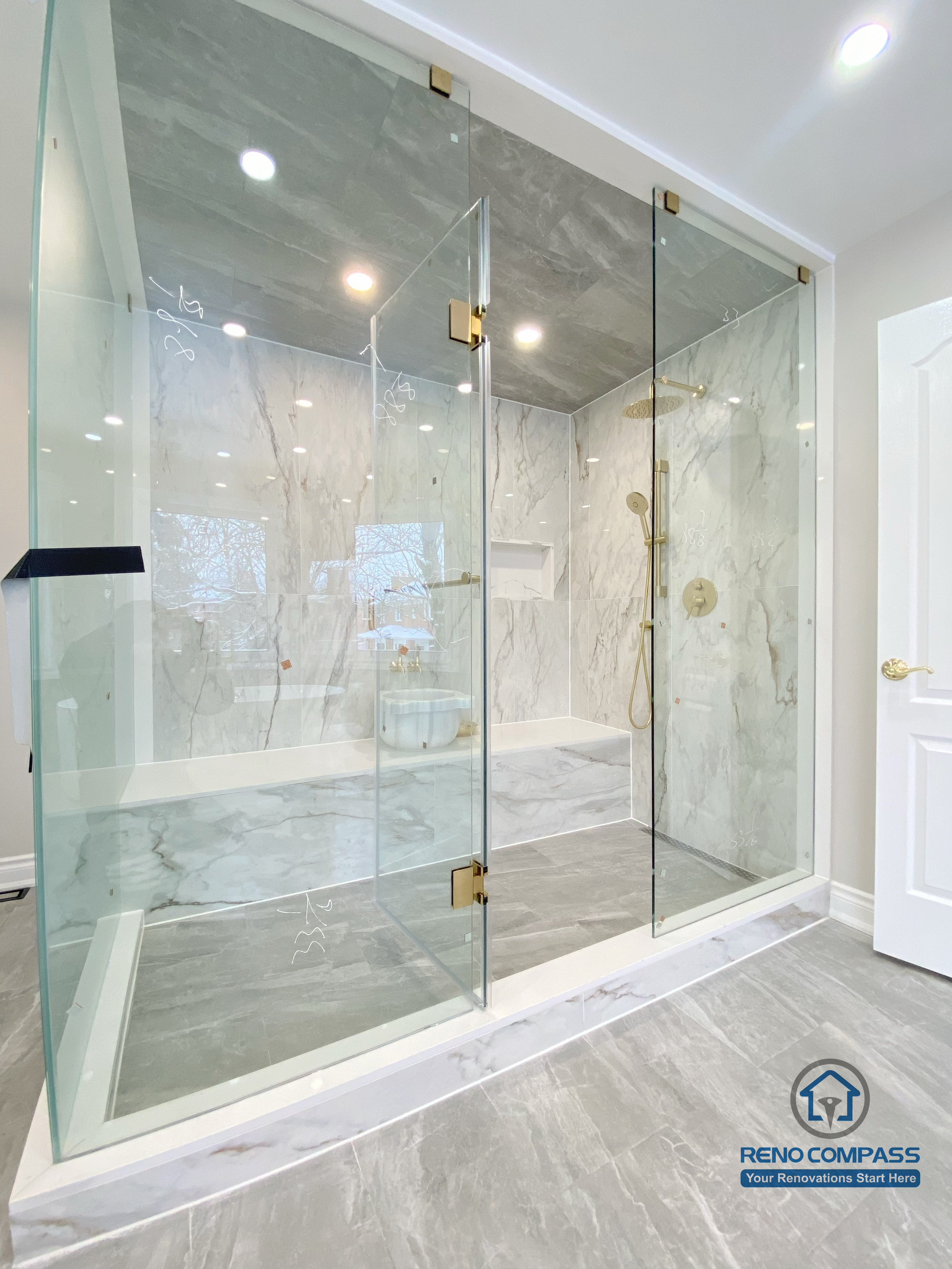 This Richmond Hill bathroom renovation showcases a bright and elegant design featuring a frameless glass shower enclosure, built-in bathtub, marble-style wall tiles, and gold-finish fixtures. The custom white vanity with integrated lighting mirror and large-format floor tiles enhance both functionality and visual openness. This project reflects high-quality craftsmanship and thoughtful layout planning for a modern bathroom renovation in Richmond Hill.