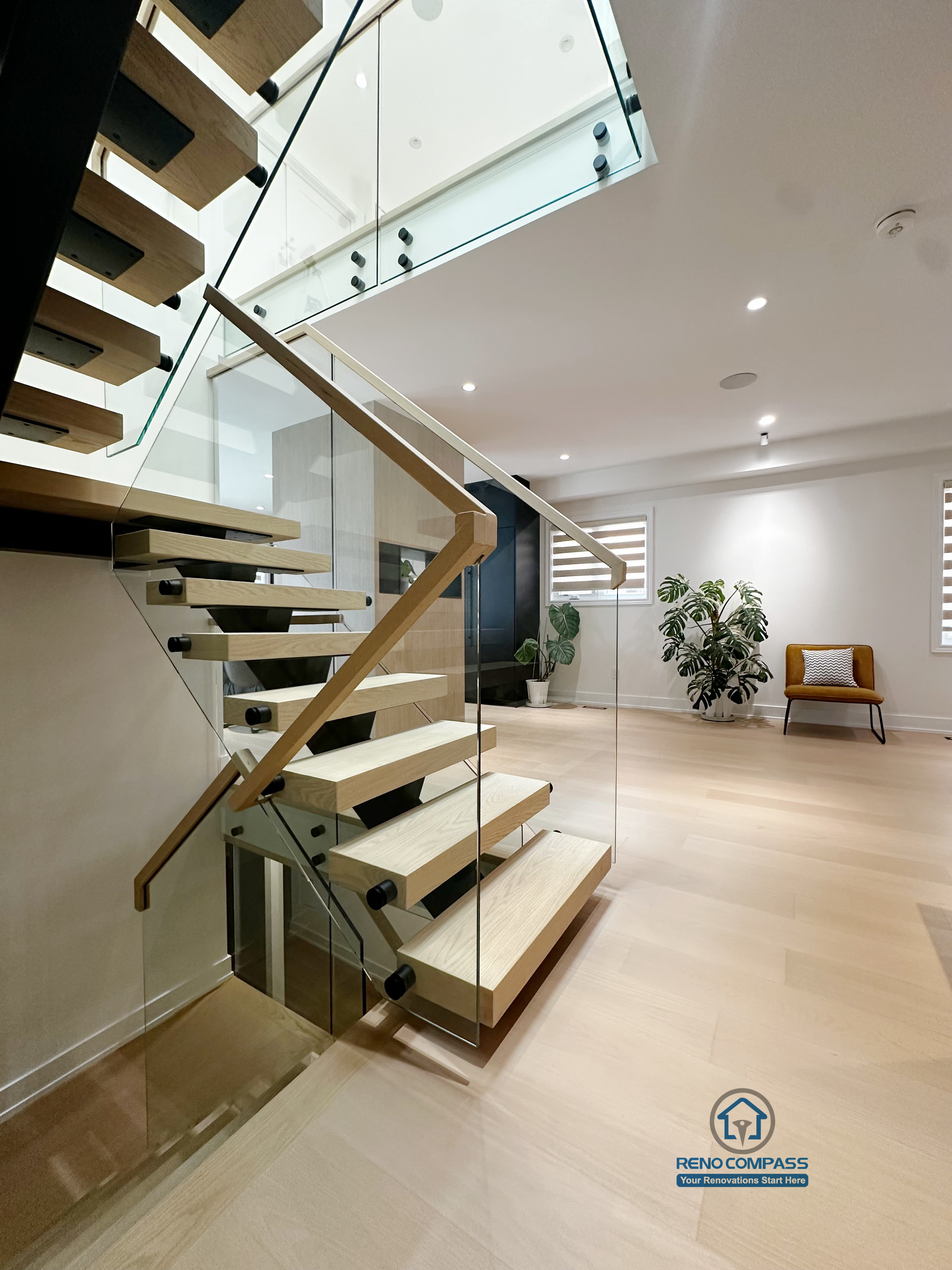 This detail view highlights the craftsmanship of the floating steel staircase, featuring solid wood treads paired with a tempered glass railing system. The design emphasizes clean lines, structural clarity, and safety, while maintaining visual openness and a seamless connection between levels.