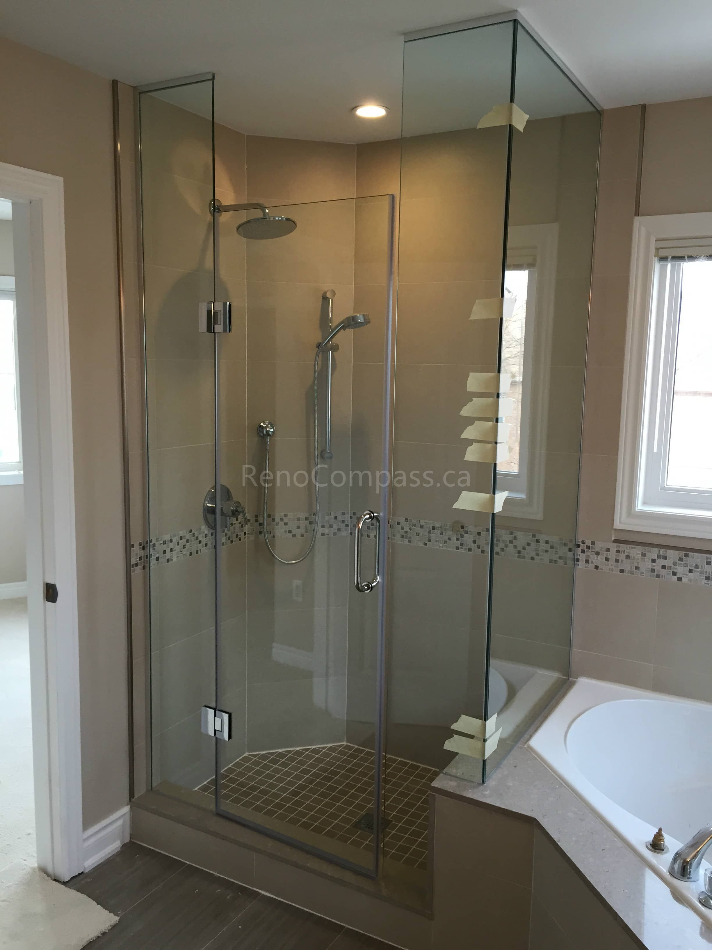 This Toronto interior renovation features a modern bathroom upgrade with a frameless glass shower enclosure, custom tile flooring, and a built-in shower niche. The neutral wall tiles combined with mosaic accent detailing create a clean and elegant look. The spacious layout includes a glass corner shower and a soaking bathtub, enhancing both functionality and comfort. Completed by Reno Compass Inc., this bathroom renovation highlights high-quality craftsmanship and contemporary design in Toronto.