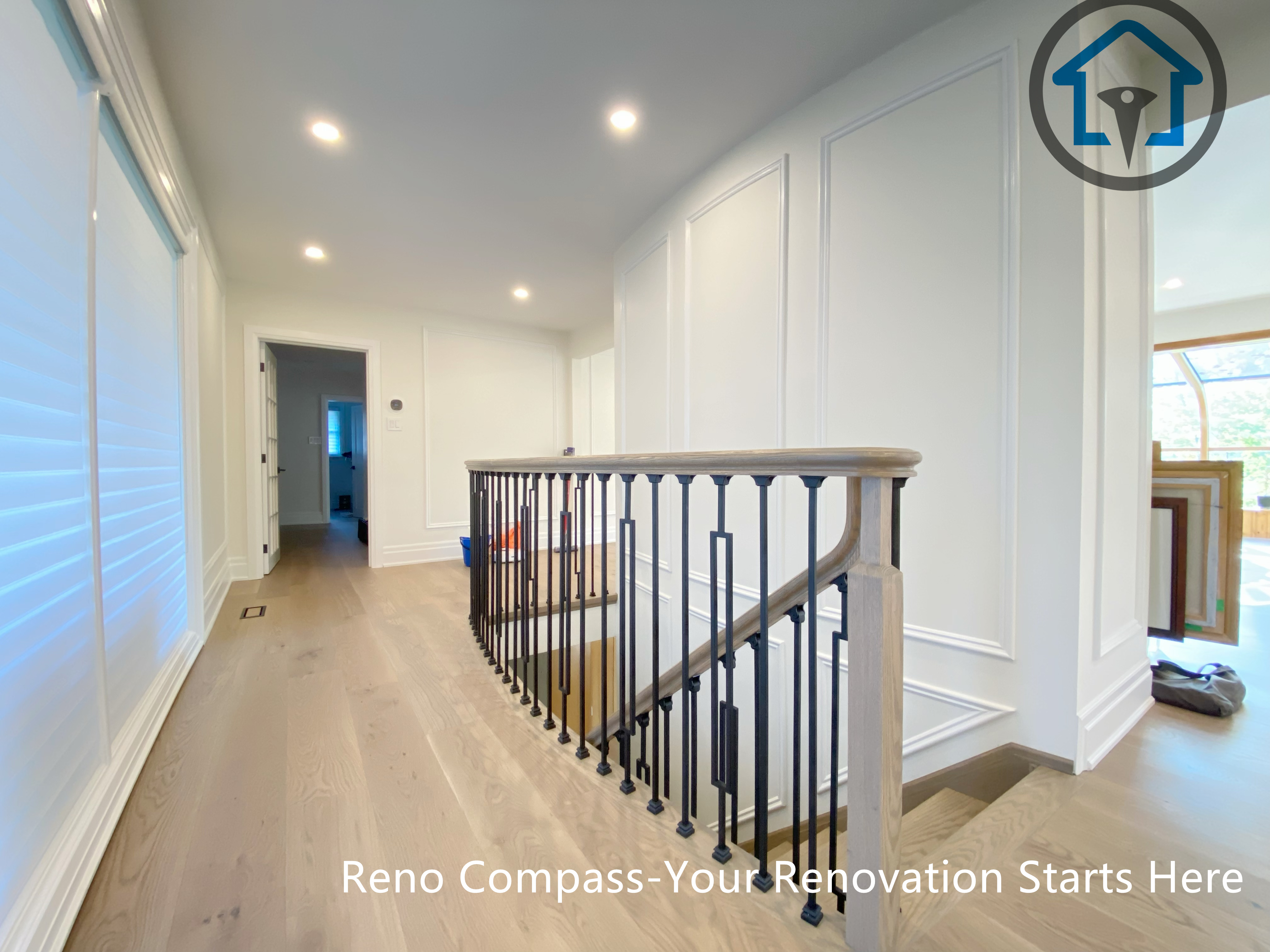 This North York house interior renovation features a refined upper hallway with custom wall paneling, wide-plank wood flooring, and a modern staircase railing. Recessed lighting and clean sightlines enhance circulation between levels, creating a bright and cohesive transition space that complements the home’s overall interior upgrade.
