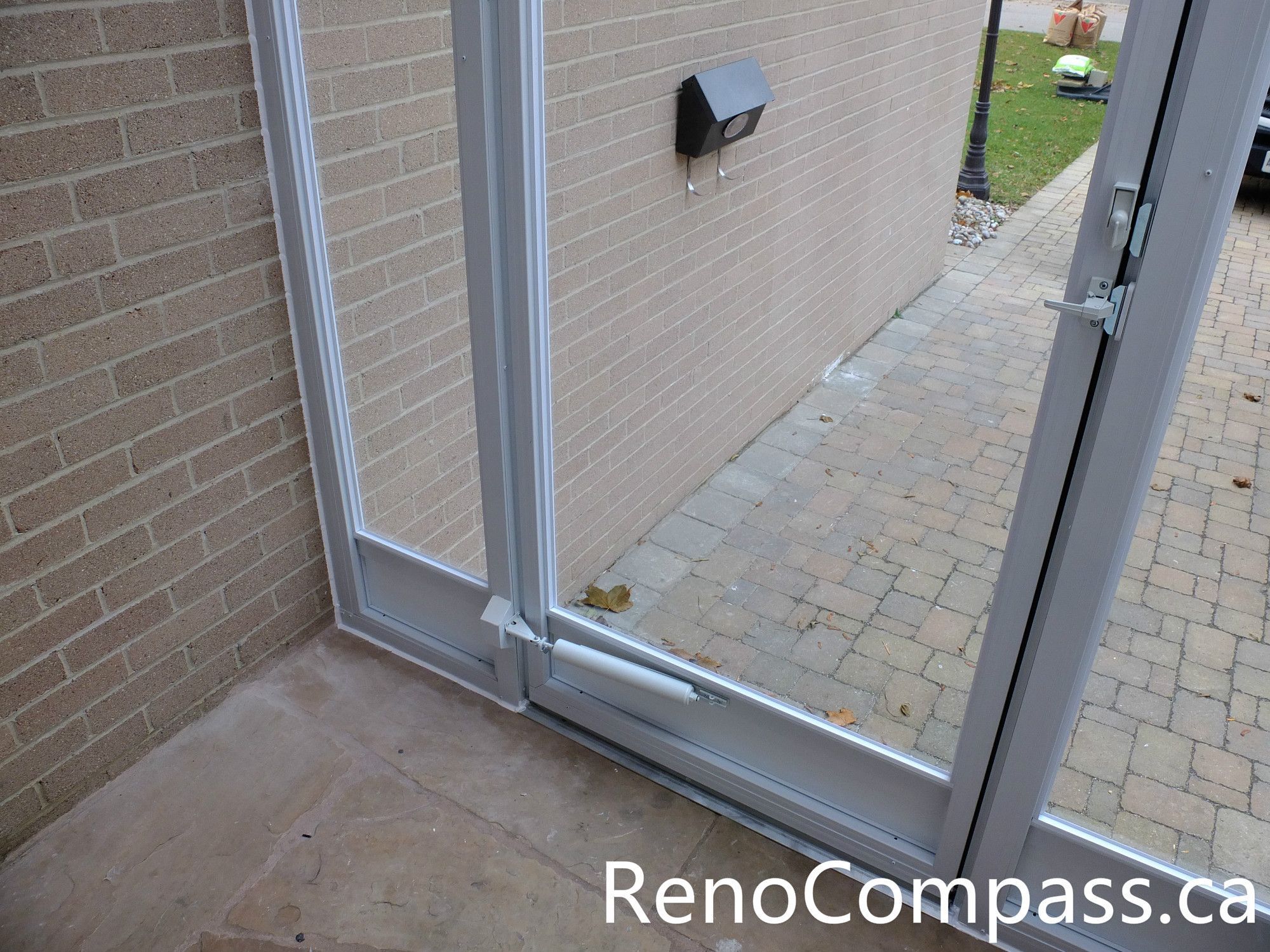 This image shows the door closer mechanism installed on a custom glass storm door at a North York home entrance. The hydraulic door closer ensures smooth and controlled closing, preventing the door from slamming while improving durability and daily usability. Combined with the aluminum frame and full glass panels, the storm door enclosure provides added insulation and protection from wind, rain, and snow. Installed by an experienced Toronto renovation team, this entrance upgrade enhances both practicality and long-term performance for the homeowner.