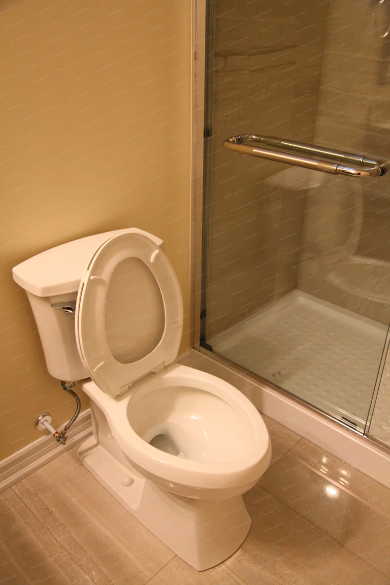 This image shows the toilet area within a finished basement bathroom in a Markham basement renovation project. Positioned beside a glass shower enclosure, the layout maximizes space efficiency while maintaining comfort and accessibility. Clean tile flooring and well-aligned fixtures contribute to a practical and easy-to-maintain basement bathroom, completed by a professional Toronto renovation company.
