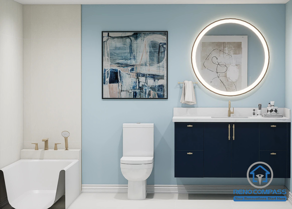 This elegant bathroom renovation features a freestanding soaking tub, custom navy vanity, illuminated round mirror, and soft blue accent wall for a fresh, contemporary look. Completed as part of a whole house renovation in North York, the space blends modern design, premium finishes, and everyday functionality to create a relaxing spa-inspired bathroom.