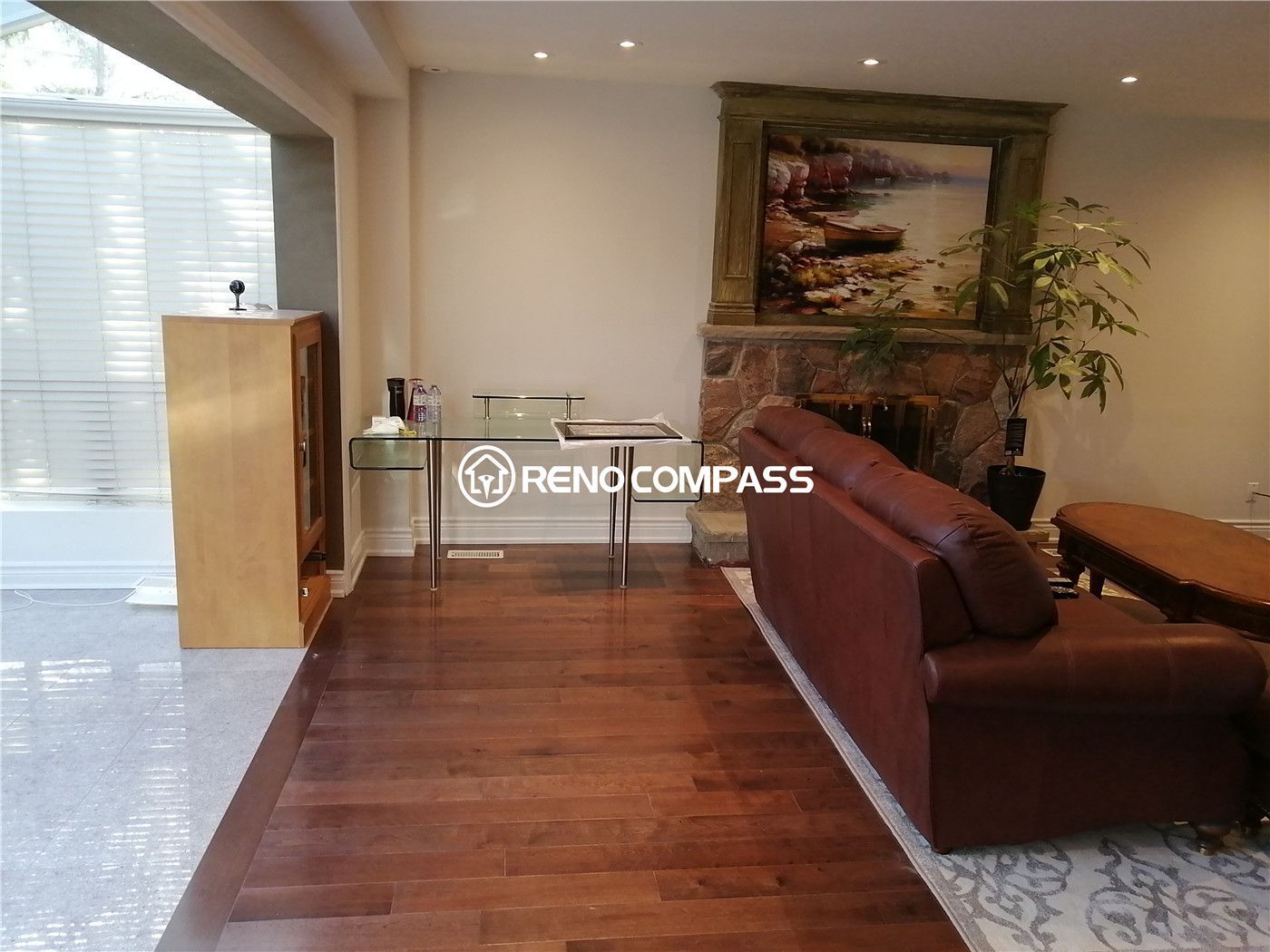 This living area is part of a North York interior renovation, designed to create a comfortable and visually grounded space for daily relaxation. The room features warm hardwood flooring, recessed ceiling lighting, and a classic fireplace feature that anchors the seating area. An open connection to adjacent spaces improves flow and functionality, while natural light enhances the overall brightness. The balanced layout and durable finishes reflect the craftsmanship and thoughtful planning expected from a professional Toronto interior renovation project.