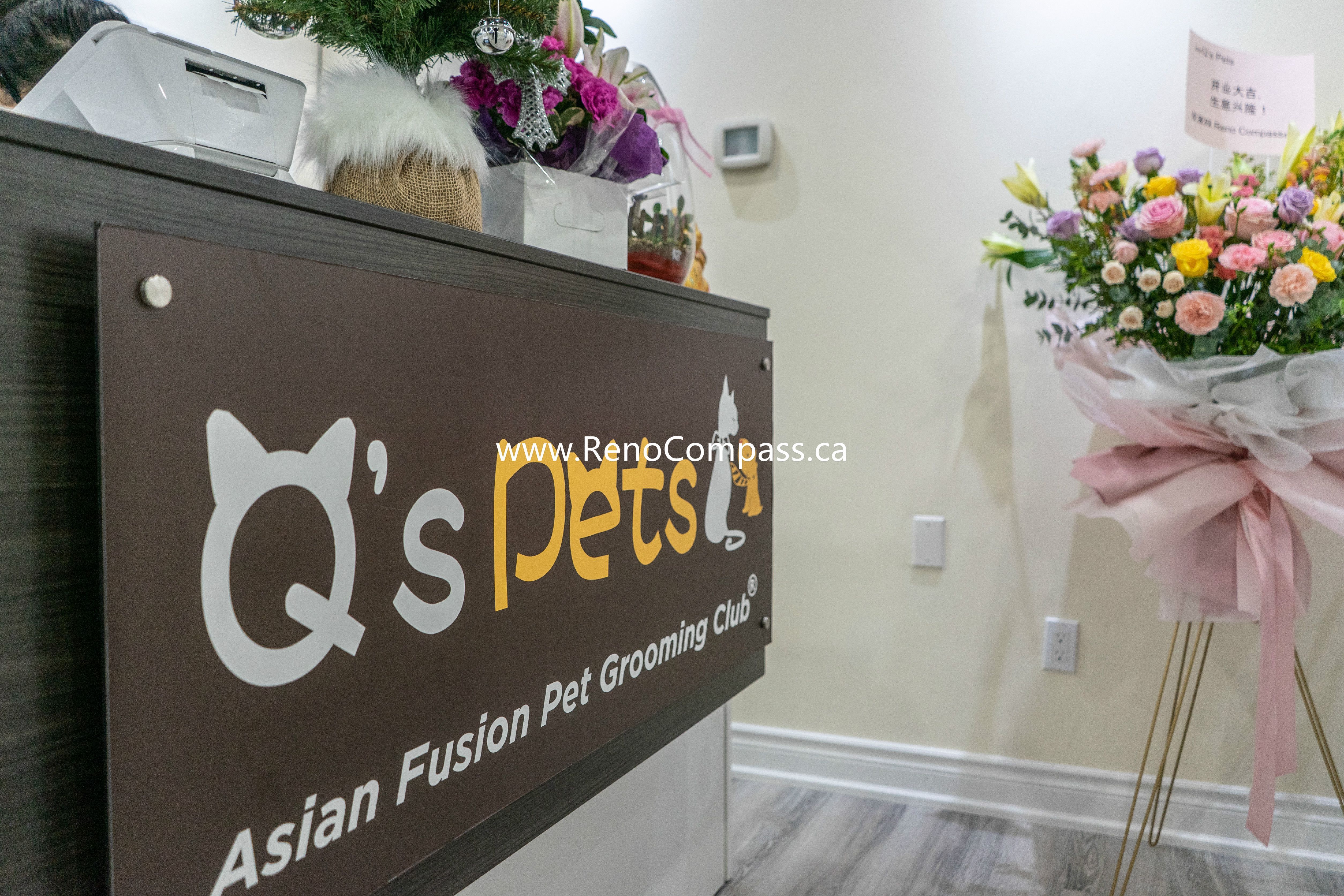 Stylish dark reception desk with wall signage and flower décor at Q’s Pets pet store renovation in Richmond Hill, completed by Reno Compass.