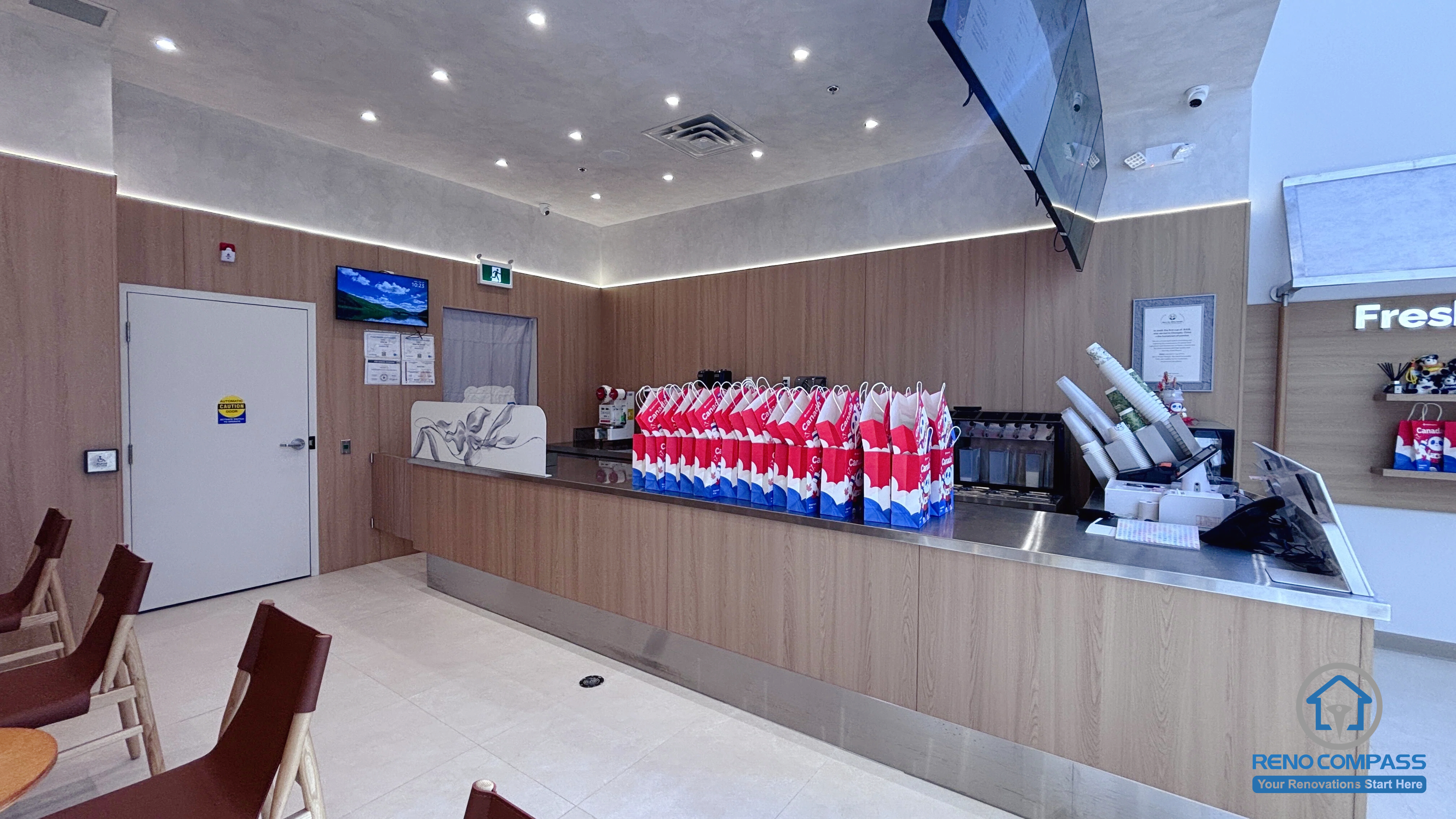 Completed TEABYDO bubble tea shop renovation in Richmond Hill featuring a modern custom beverage preparation counter, wood-tone commercial millwork, integrated LED ceiling lighting, minimalist café interior design, and optimized service workflow layout. Commercial renovation project completed by Reno Compass serving Richmond Hill, Toronto, and the GTA.