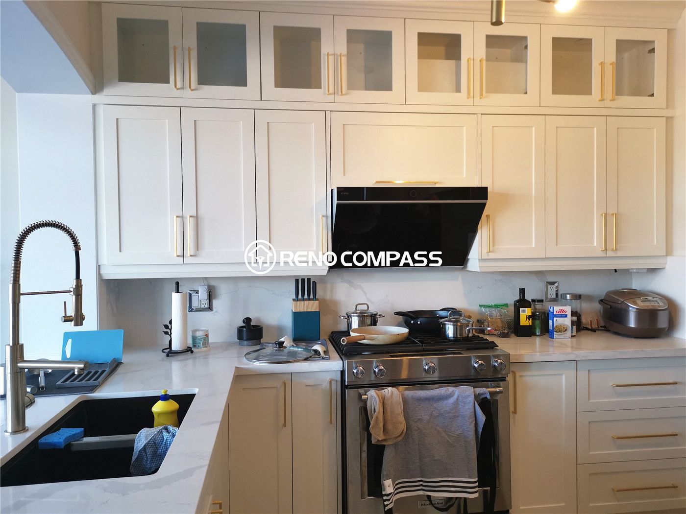 This King City kitchen renovation features custom-built white cabinetry, elegant quartz countertops, and a functional modern layout designed for everyday family living. The space was upgraded with full-height cabinets for maximum storage, a contemporary lighting fixture, and high-end stainless steel appliances to create a bright, refined, and highly practical kitchen environment. Designed and built by Reno Compass Inc., this kitchen transformation blends timeless design with modern functionality for a comfortable and stylish home upgrade.
