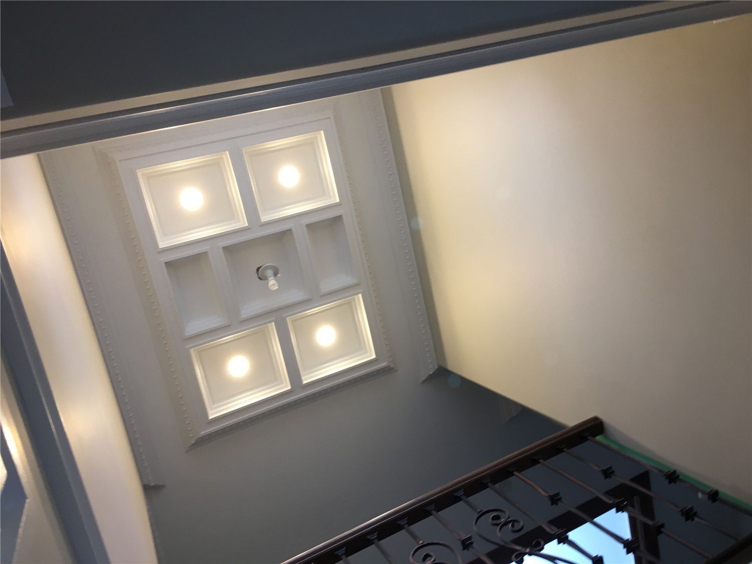 Elegant coffered ceiling design above the staircase featuring recessed LED lighting and detailed trim work. This Toronto interior renovation highlights refined ceiling craftsmanship and modern lighting design by a professional Toronto renovation company.