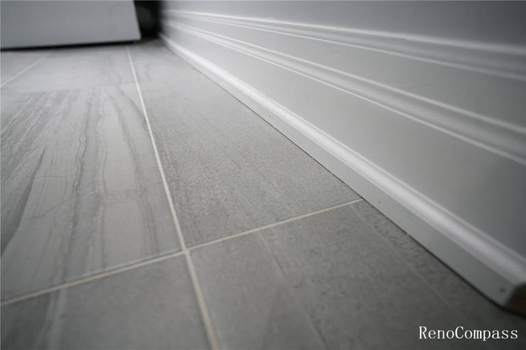 High‑resolution close‑up of newly installed grey tile flooring with clean white baseboards, showcasing quality basement renovation work in Mississauga. Perfect for highlighting craftsmanship, flooring upgrades, and interior finishing details.