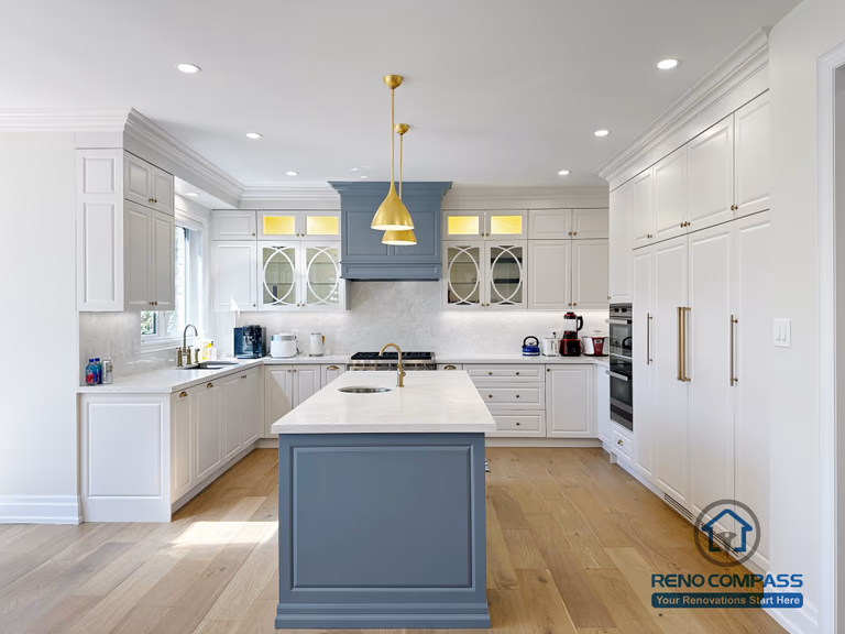 This North York kitchen renovation features a spacious central island with quartz countertops, custom cabinetry in a soft blue and white palette, and integrated pendant lighting. The open-concept layout enhances natural light and flow between the kitchen and dining area, creating a functional and elegant space designed for everyday living and entertaining. Completed by Reno Compass with a focus on craftsmanship, proportion, and long-term usability.