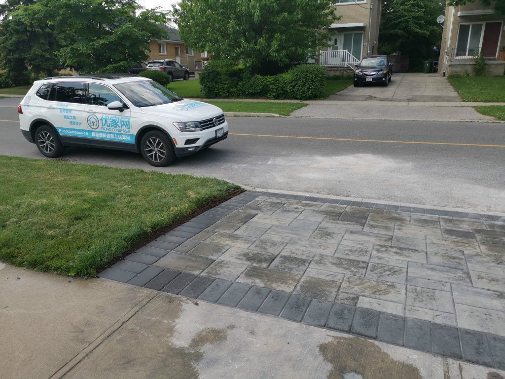 Interlocking driveway and walkway completed as part of a North York exterior renovation project. This installation features durable concrete pavers arranged in a clean, modern pattern, creating a seamless transition between the driveway, sidewalk, and front yard landscaping. The curved edge detailing improves visual flow while maintaining proper alignment and surface stability. Designed for long-term performance and curb appeal, this driveway interlocking project was completed by a Toronto renovation company with a focus on craftsmanship, drainage consideration, and everyday functionality.