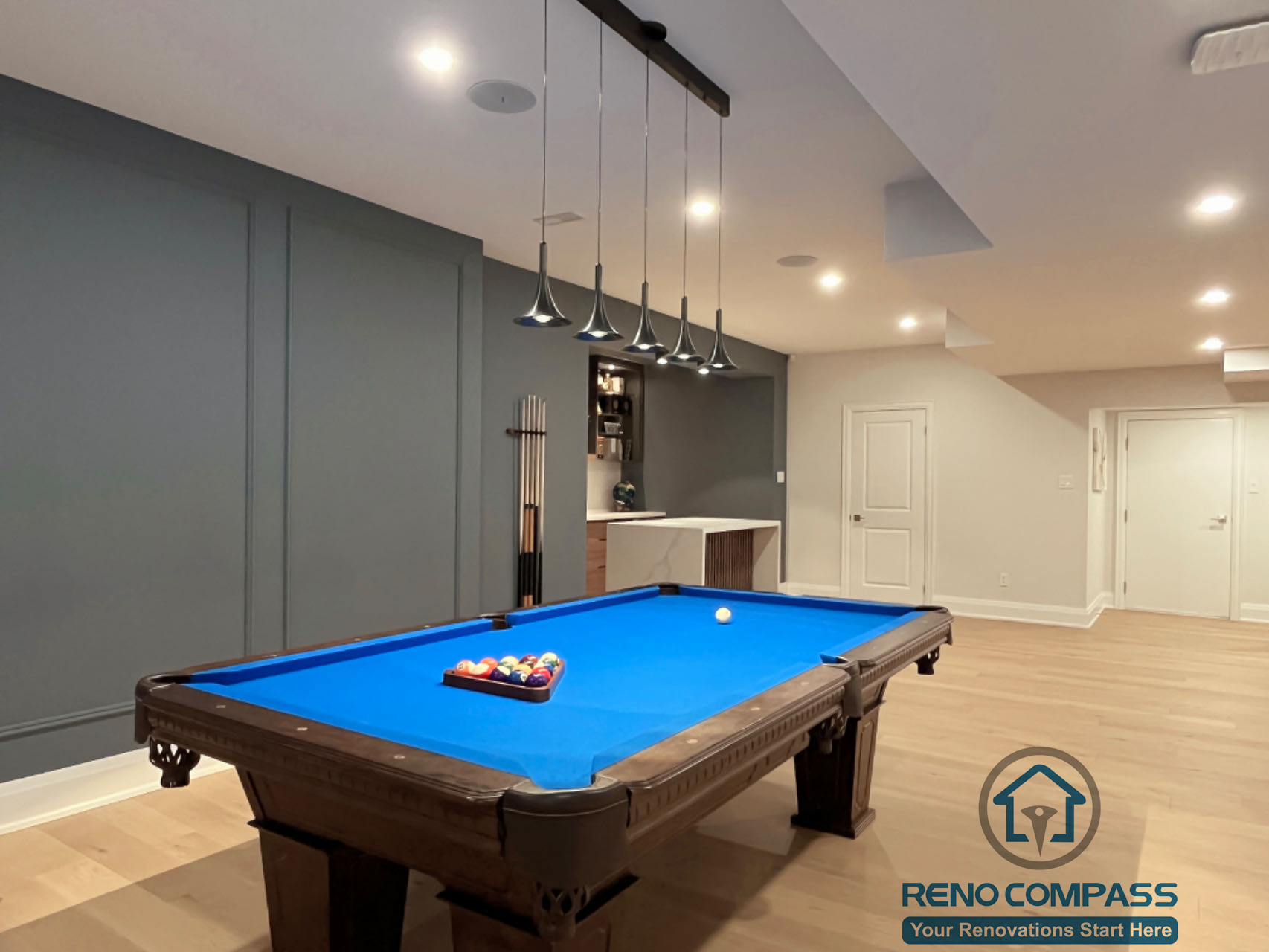 Finished basement renovation in Newmarket featuring a custom pool table area, modern lighting, wood flooring, and a clean open-concept layout designed for entertainment and relaxation.