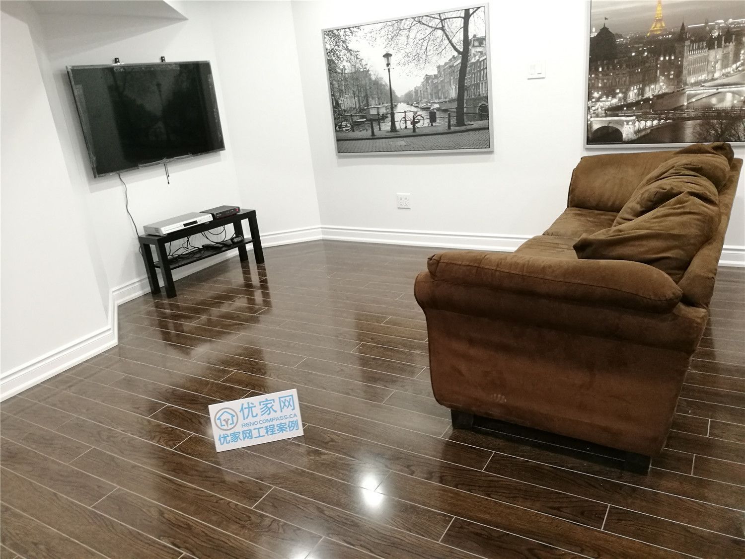 This Markham basement renovation features a clean and inviting TV lounge designed for everyday comfort and relaxation. The space showcases glossy dark hardwood flooring, recessed ceiling lights, and a minimalist wall-mounted TV setup that maximizes floor area. Neutral white walls paired with modern artwork create a bright, contemporary atmosphere, while the open layout provides flexibility for family entertainment or guest gatherings. Professionally renovated with attention to detail, this basement living area upgrade enhances both functionality and home value in Markham.
