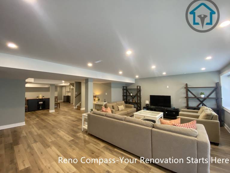 An open-concept basement living area completed as part of a Vaughan basement renovation. This finished basement features recessed ceiling lighting, integrated structural columns, durable wood-look flooring, and a spacious layout designed for family gatherings, entertainment, and everyday relaxation.