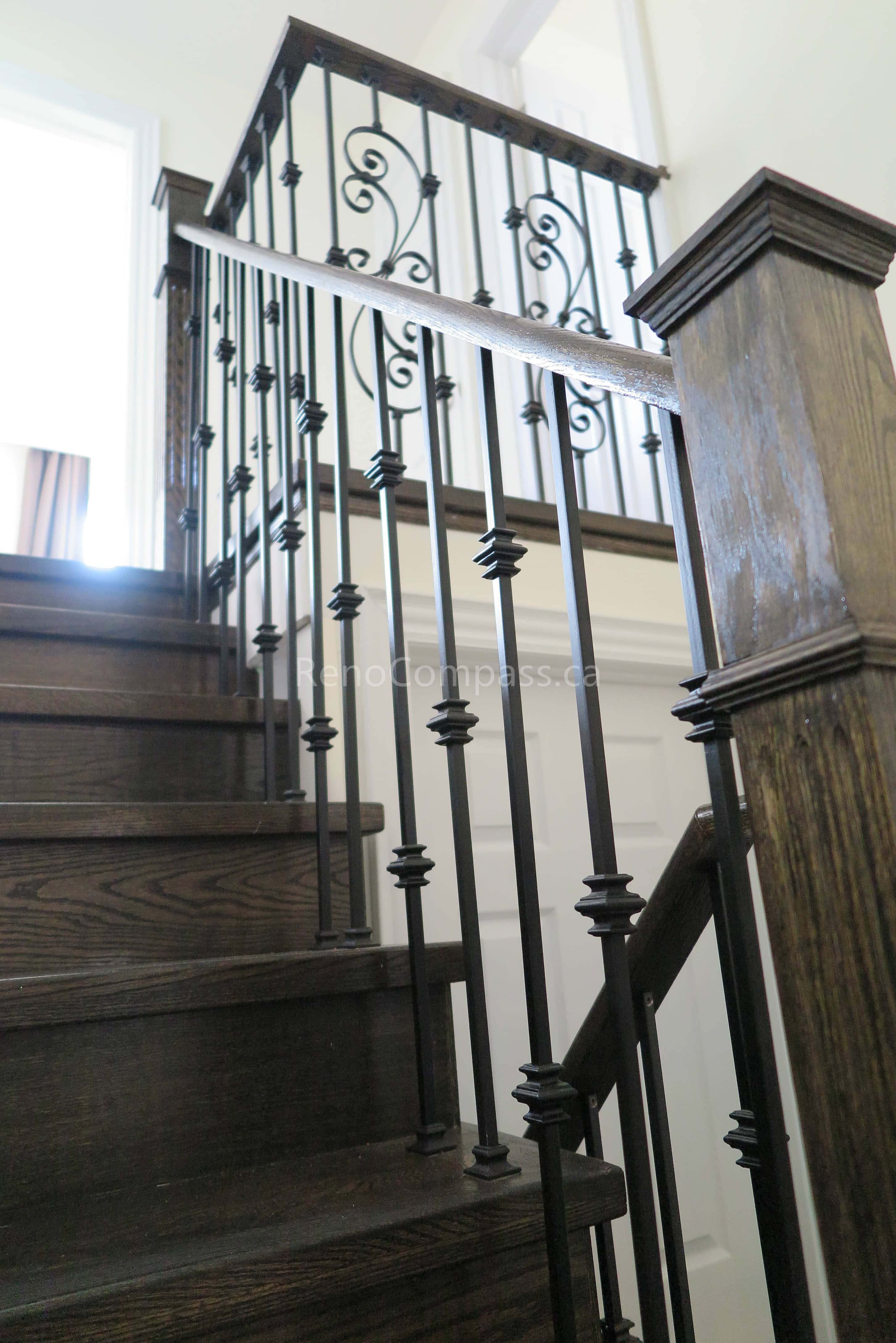 This North York interior renovation showcases a beautifully upgraded staircase featuring dark-stained wood steps and custom wrought iron railings. The combination of elegant iron balusters and rich wood finishes adds a timeless and sophisticated look to the home’s interior. Completed by Reno Compass Inc., this staircase renovation enhances safety, durability, and modern design while elevating the overall visual appeal of the space.