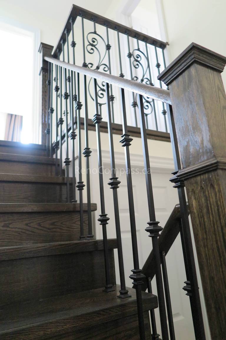 This North York interior renovation showcases a beautifully upgraded staircase featuring dark-stained wood steps and custom wrought iron railings. The combination of elegant iron balusters and rich wood finishes adds a timeless and sophisticated look to the home’s interior. Completed by Reno Compass Inc., this staircase renovation enhances safety, durability, and modern design while elevating the overall visual appeal of the space.